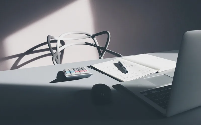 مكتب عمل عليه حاسوب وآلة حاسبة ودفتر